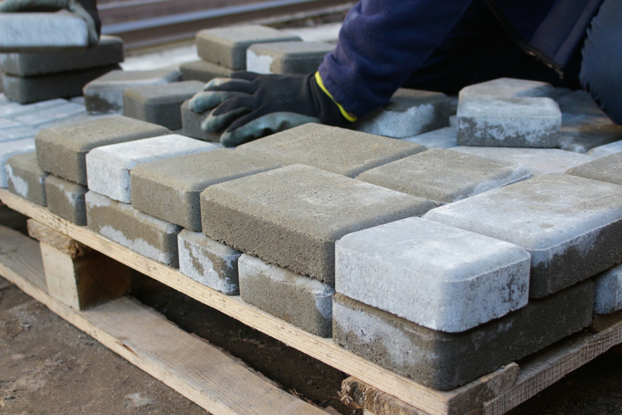 Mitra Terpercaya Anda dalam Solusi Material Konstruksi Precast 7 paver master. Man lays paving stones in layers. Garden brick pathway paving by professional worker.